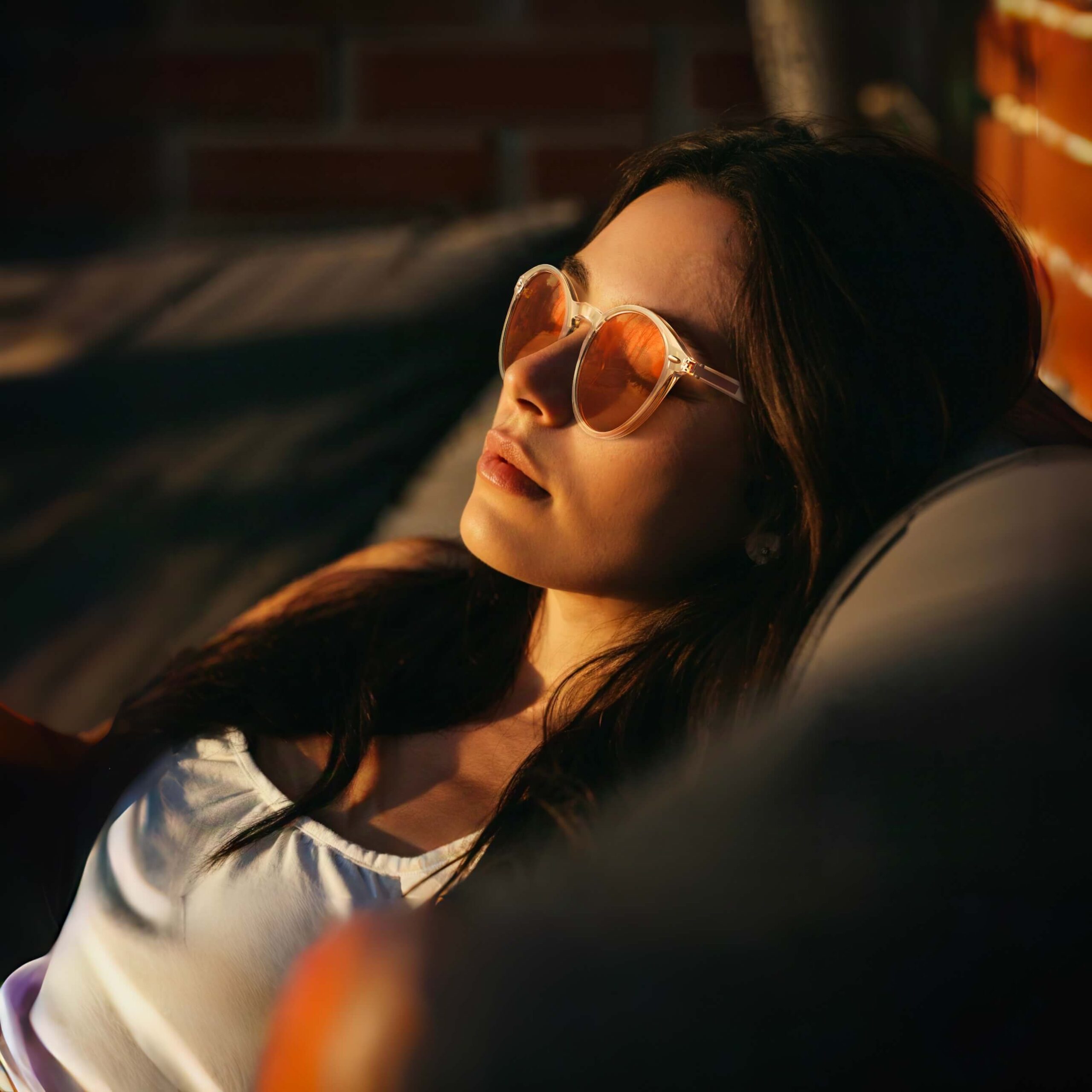 a young girl is napping in a sofa outside and relaxing with night ease round sleep glasses with clear frame