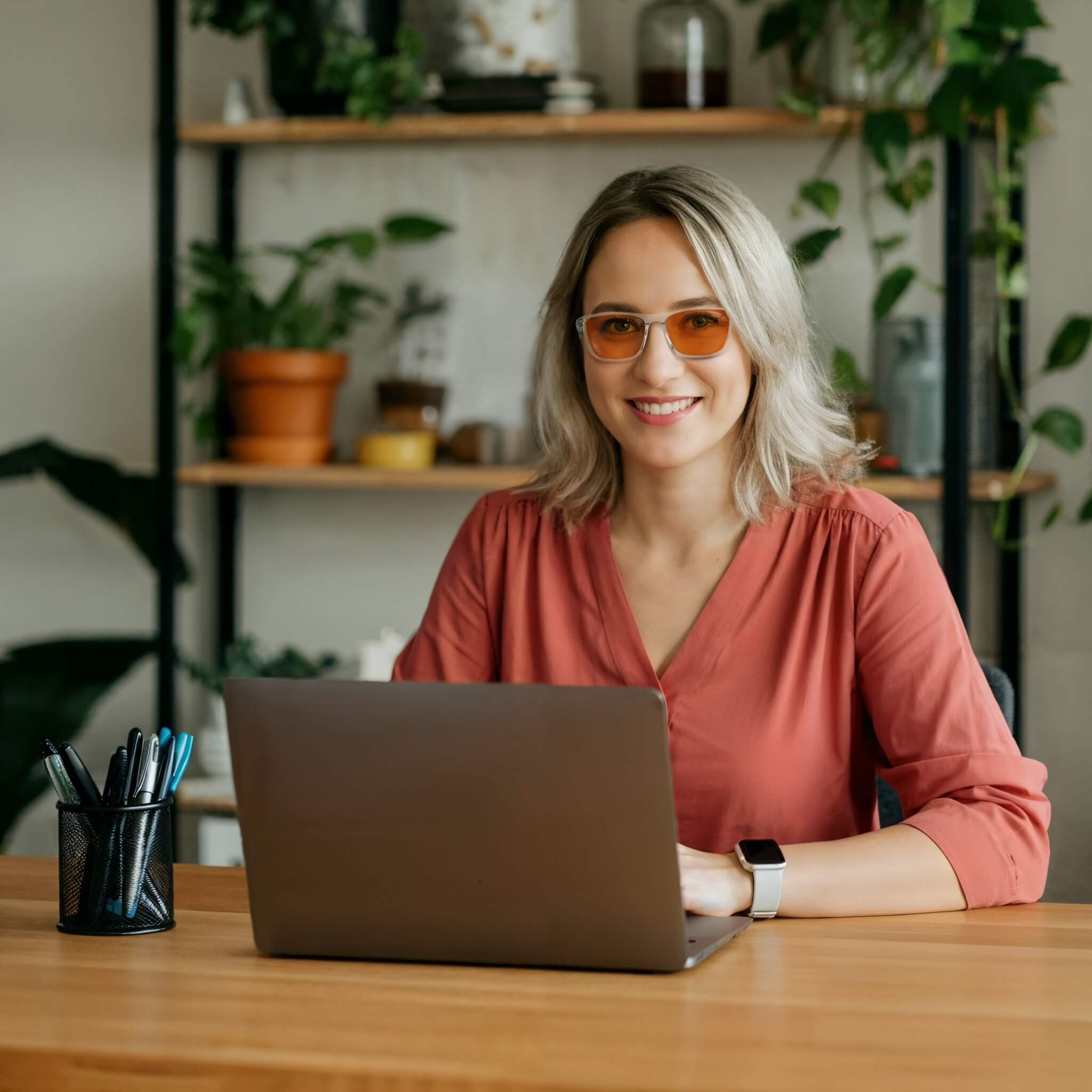 an elegant female is looking at camera and smiling with night ease wayfarer sleep glasses with clear frame