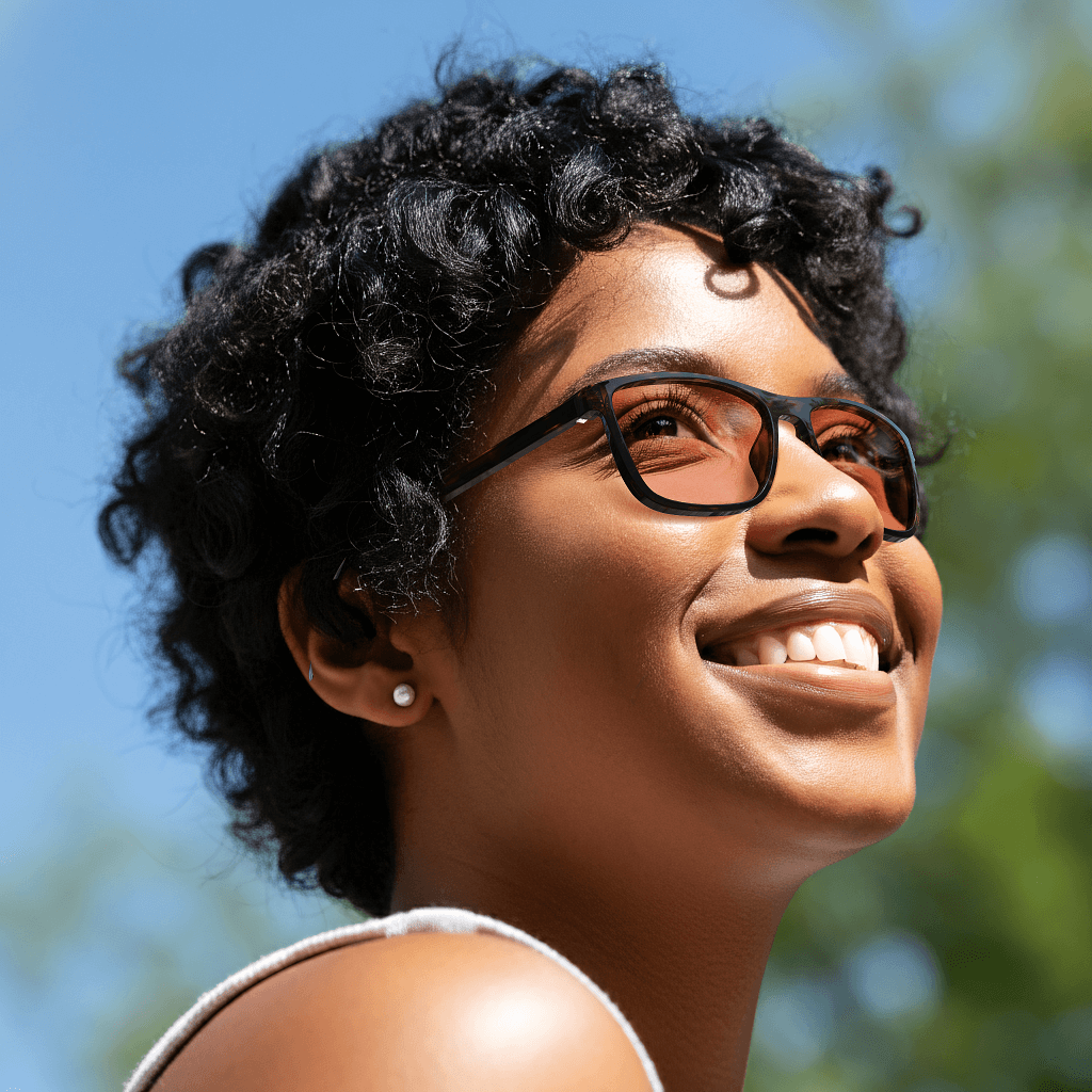 a young girl is wearing rose relief wayfarer migraine glasses with tortoiseshell frame outside for blocking out the glare of the sun during the day