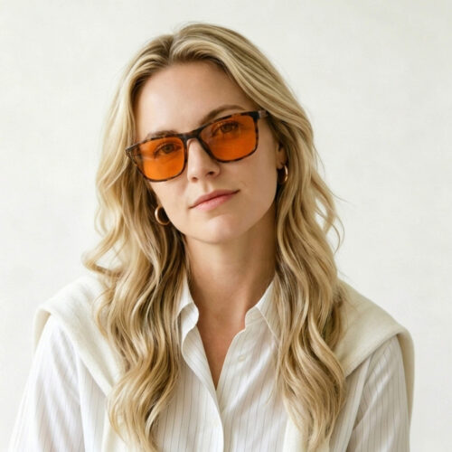 168-Female model wearing Gloojo Night Ease sleep glasses with orange lenses and a classic tortoise shell frame