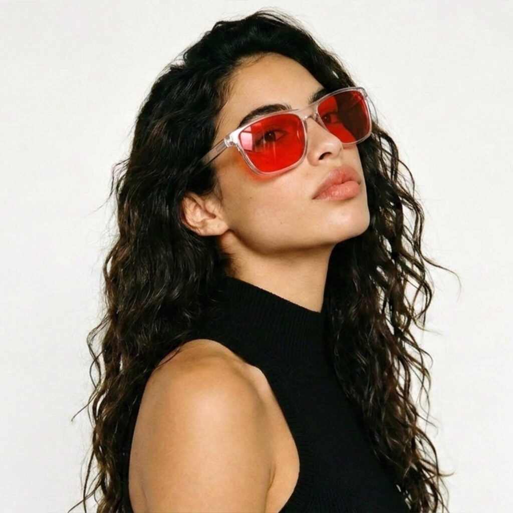 168-Female model wearing Gloojo Night Ease sleep glasses with red tinted lenses in a crystal frame